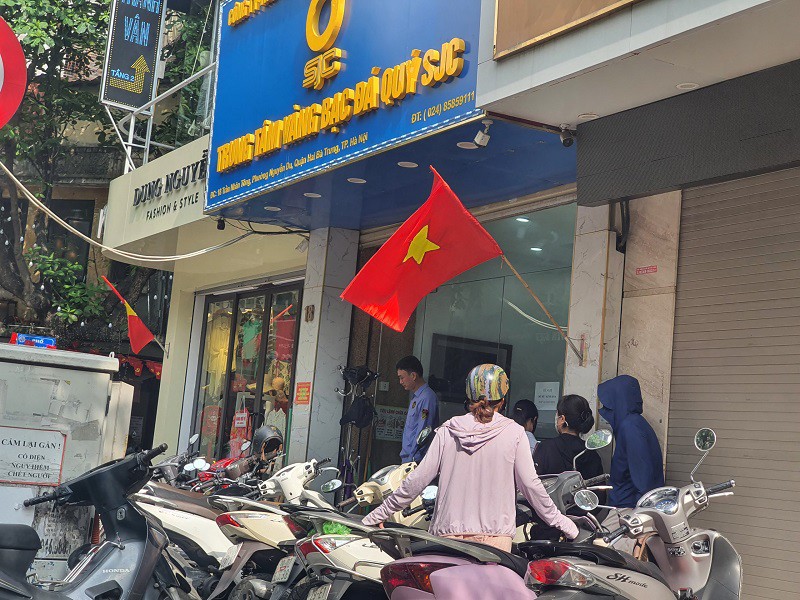 Một số người xếp hàng ở trước cửa Trung tâm vàng bạc Đá quý SJC từ khi chưa mở cửa giao dịch.