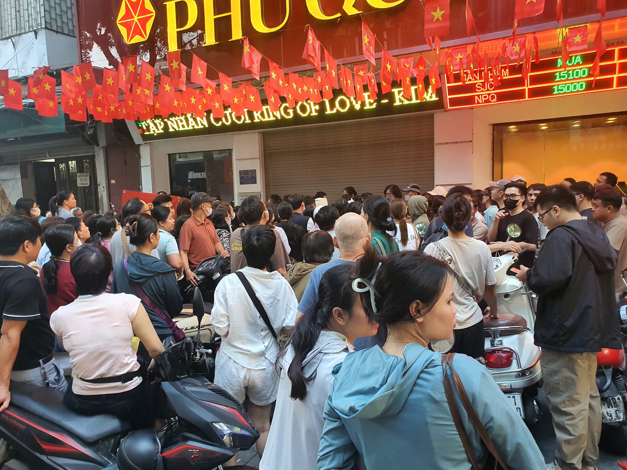 Hàng trăm người xếp hàng lấy số trước cửa hàng trên phố vàng.