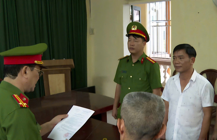 Cơ quan điều tra tống đạt các quyết định khởi tố, thi hành lệnh bắt bị can để tạm giam đối với Nguyễn Thế Bảo (áo trắng).