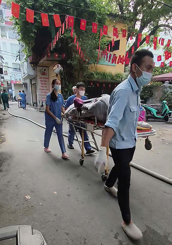 Thi thể được bọc kín bằng chăn đưa ra ngoài. Ảnh: Huy Mạnh