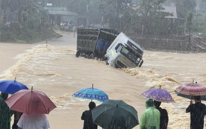 Xe đầu kéo vượt qua cầu tràn nước lũ chảy xiết bị cuốn trôi. Ảnh: Văn Đỗ