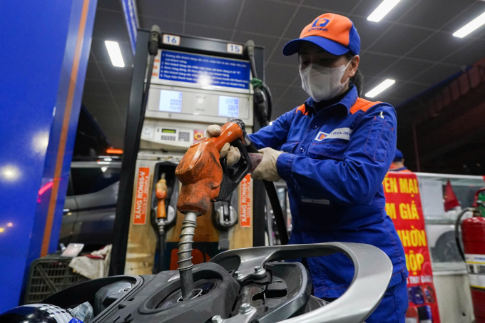 Nhân viên một cửa hàng ở đường Láng, Hà Nội bơm xăng cho khách hàng, ngày 11/3. Ảnh: Hoàng Giang